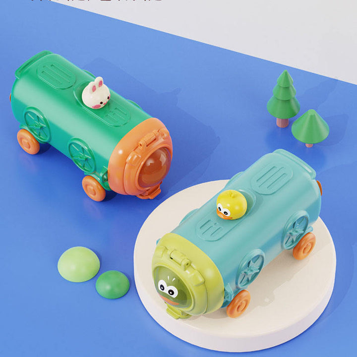 Two green toy trains on a blue surface with small trees and rocks.