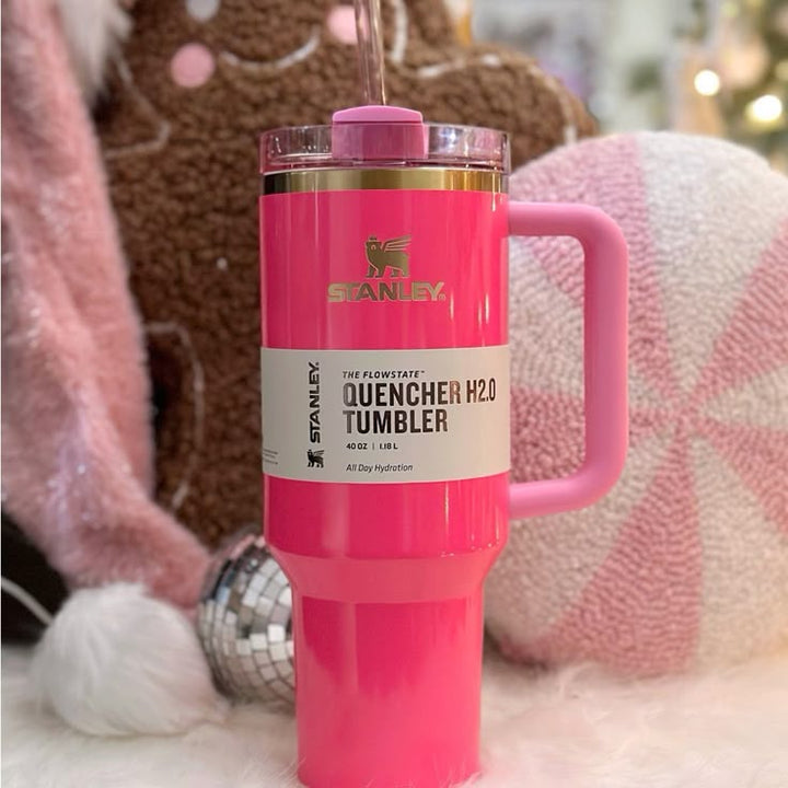 Pink Stanley Quencher H2O tumbler with a handle on a soft, blurred background