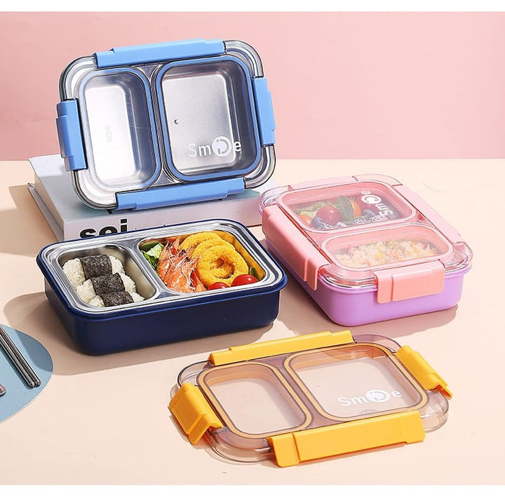 Colorful bento boxes with food compartments on a pink background