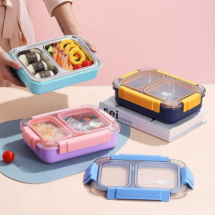 Colorful bento boxes with food compartments on a light pink background