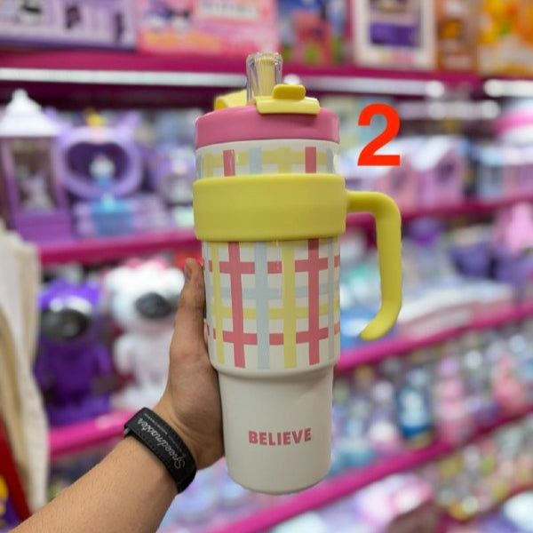 Colorful water bottle with plaid design and 'BELIEVE' text held in front of a store shelf.